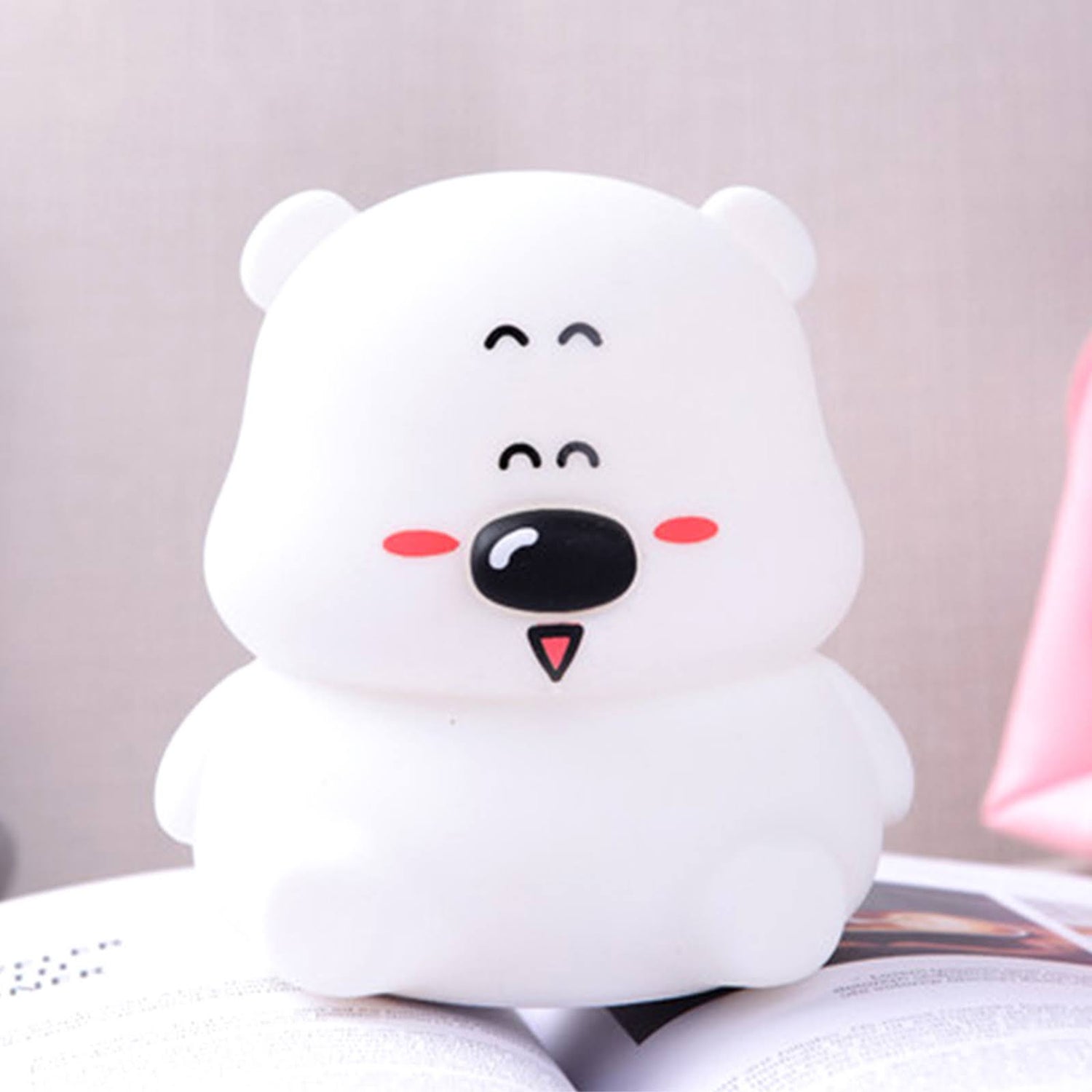 Lampe en forme d'ourson blanc sur un livre