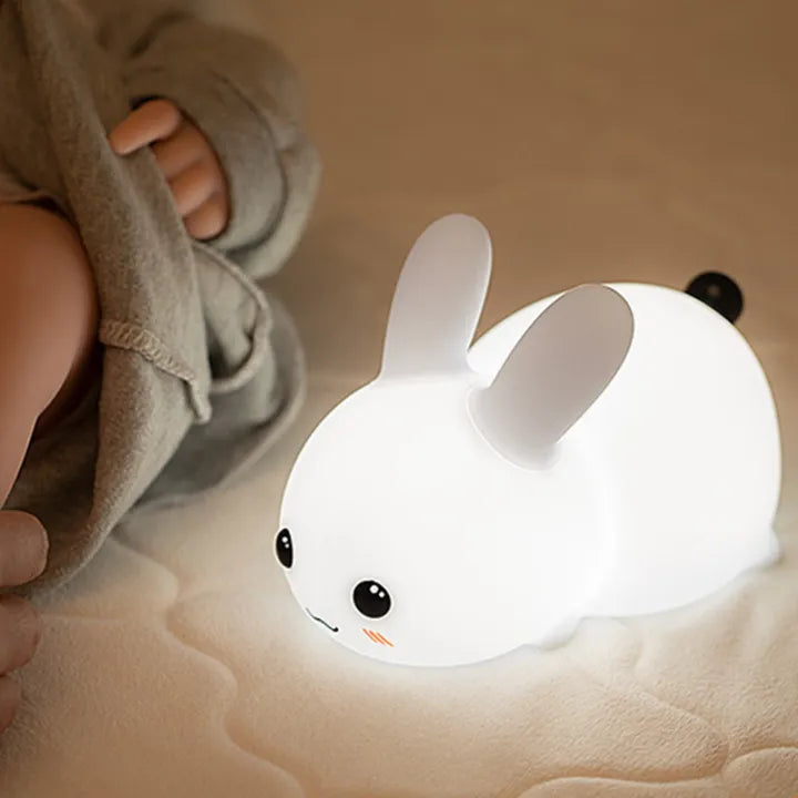 Petite veilleuse en forme de bébé lapin avec la fonction lumineuse activée en blanc