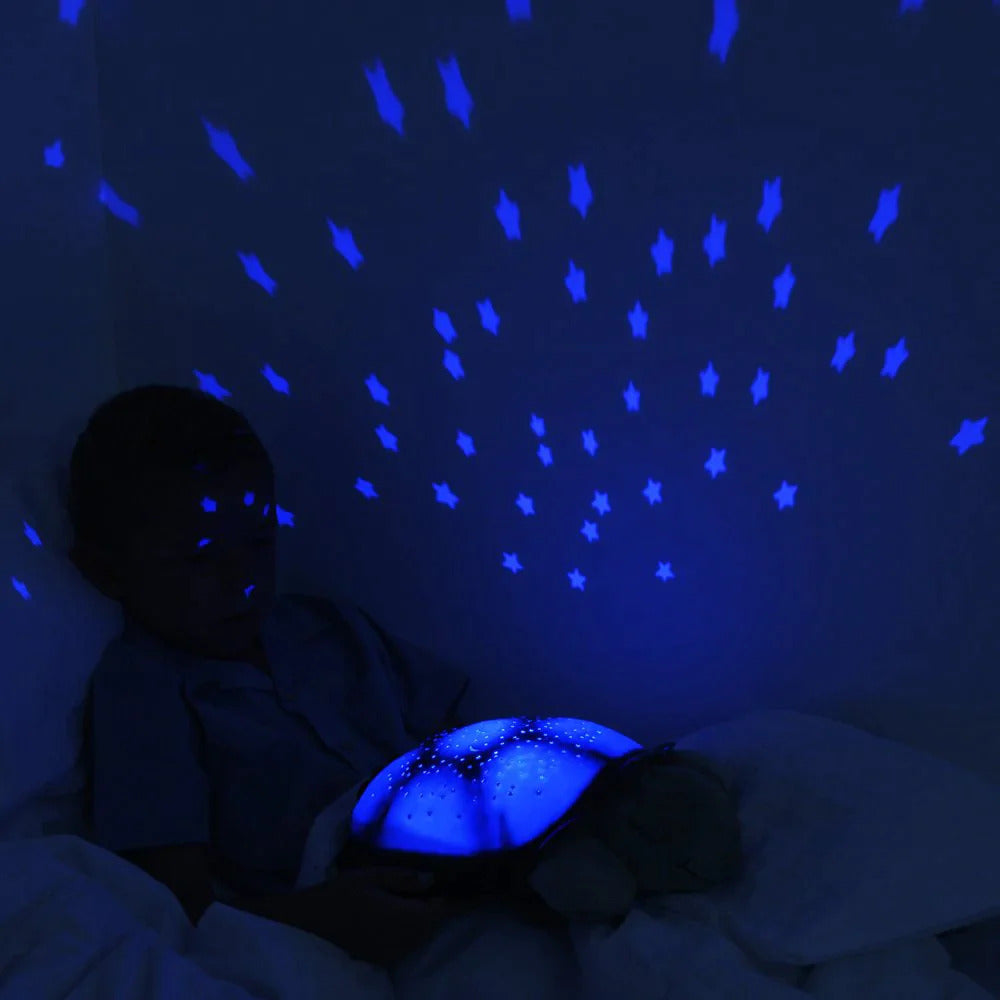Veilleuse tortue avec la fonction de projection de ciel étoilée de couleur bleu activée dans la chambre d'un enfant
