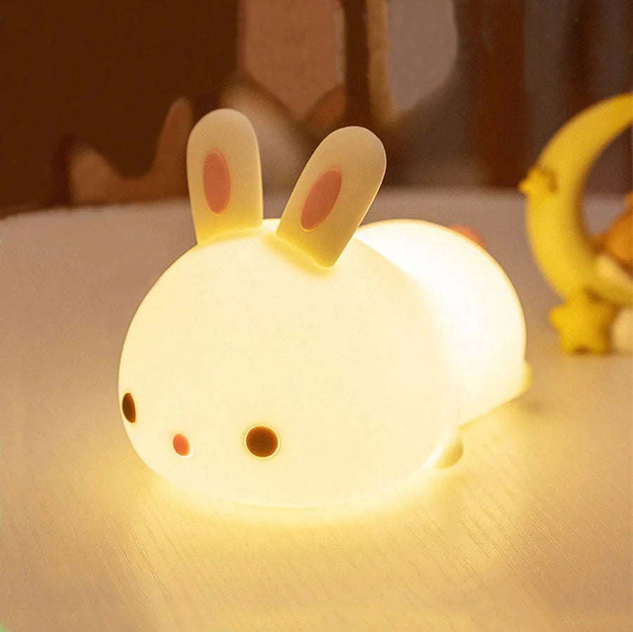 Veilleuse en forme de lapin bébé sur une table avec la fonction lumineuse activée
