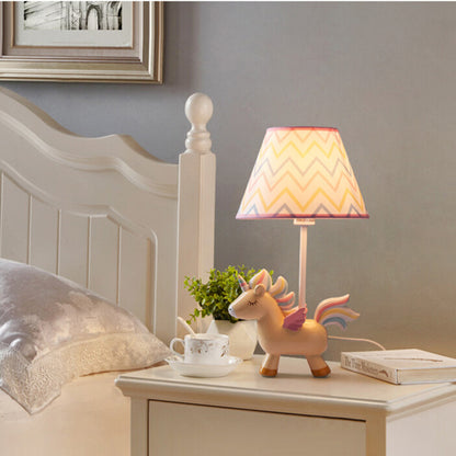 Lampe de chevet en forme de licorne posée sur une table de chevet