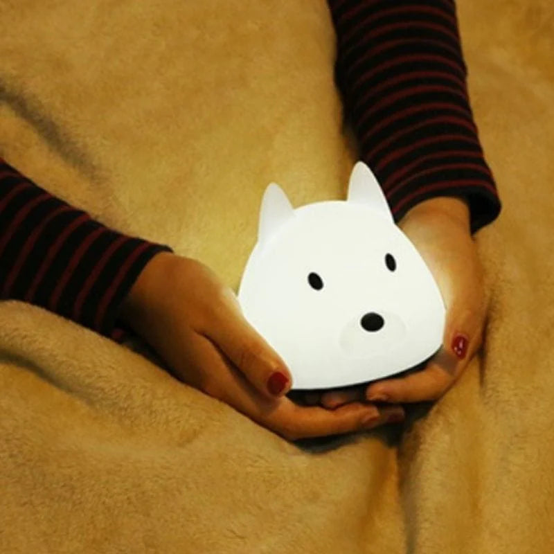 Lampe lumineuse pour bébé en forme de renard de couleur blanche dans des mains de femme