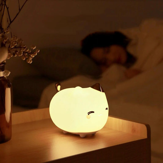 Lampe veilleuse en forme de bébé chat posée sur une table