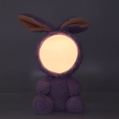 Peluche veilleuse en forme de lapin dans le noir avec la fonction lumineuse activée
