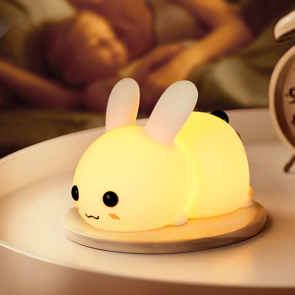 Petite veilleuse en forme de bébé lapin présentée sur une table de chevet