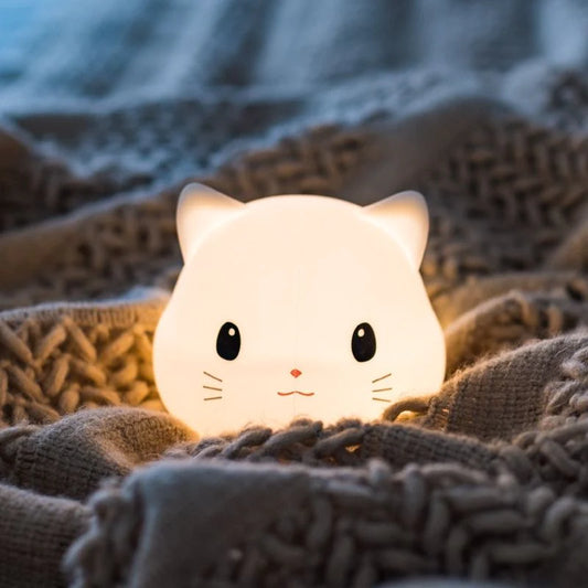 Veilleuse pour bébé en forme de chat posé sur un lit