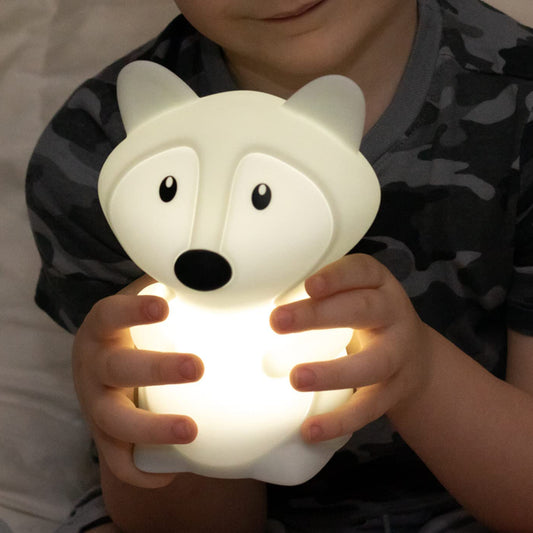 Veilleuse pour bébé en forme de renard blanc présentée dans les mains d'un petit garçon