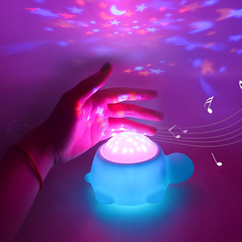 Veilleuse tortue aquatique bleu avec une démonstration de la fonction de projection rose activée sur une main